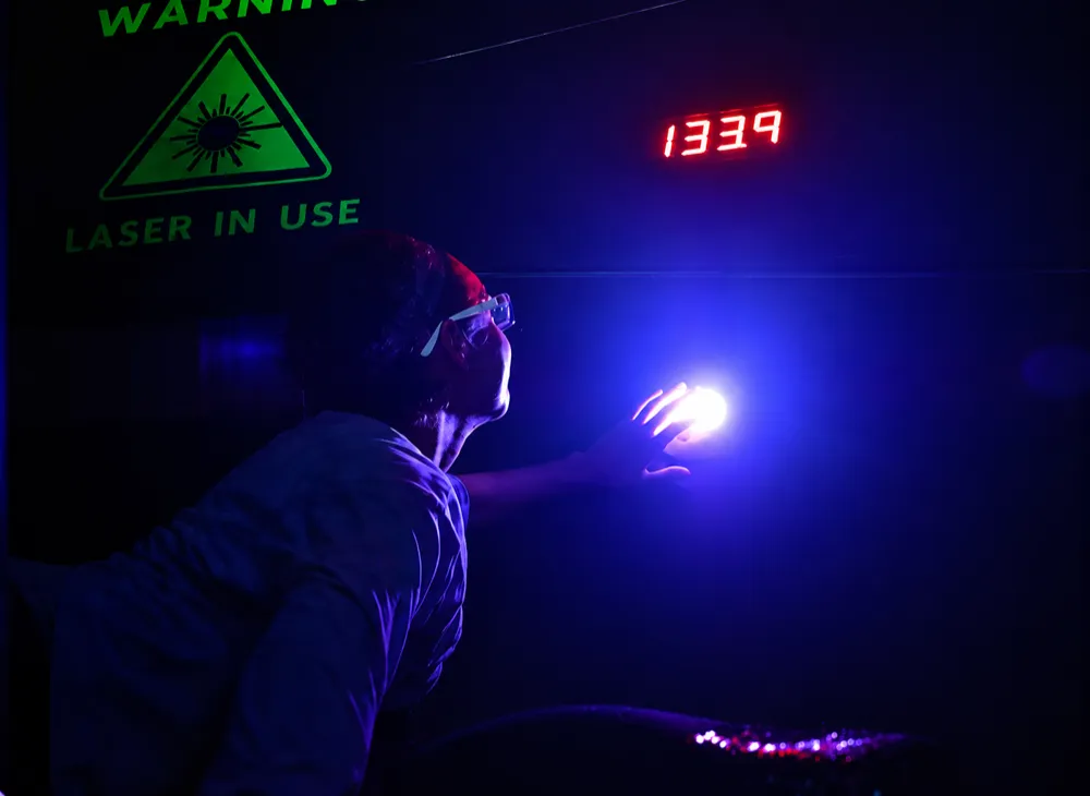 A guest pressing the glowing finish button under the red digital timer and the Laser In Use sign