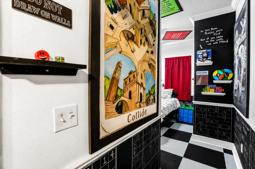 The Collide painting in the Mind Games hall beside the Do Not Draw On Walls sign, a shelf with a Simon and a Tetris lamp, sudoku chalkboards below