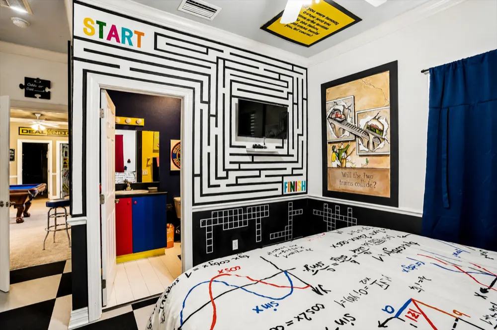 A maze painted from START to FINISH around the wall-mounted TV, the Rubik bath through the open door, equation bedding in front