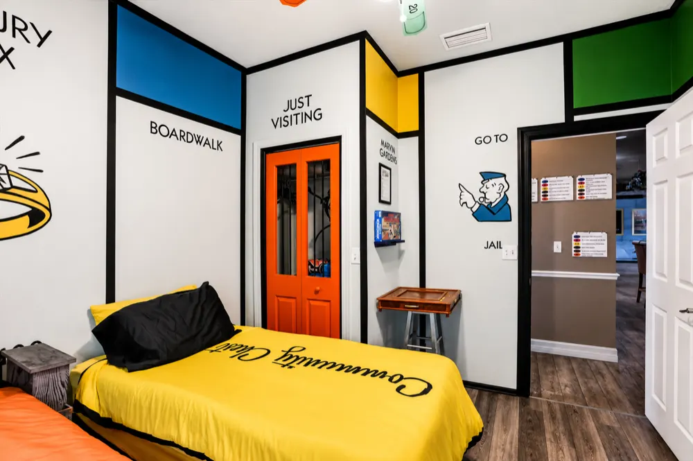 The Monopoly bedroom: the orange Just Visiting jail door, the Go To Jail policeman on the wall, and the Community Chest bed