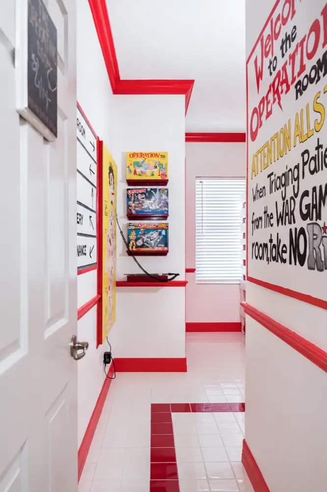 The Operation room hallway with the three small Operation editions on red shelves and the hospital notice painted on the wall