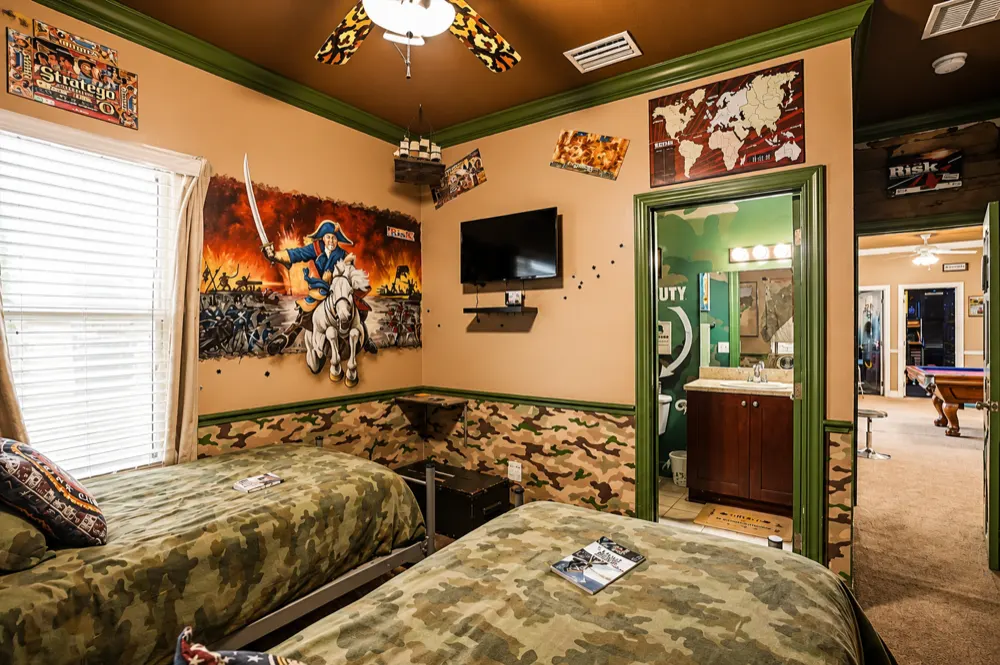 War Games bedroom: two camo twin beds, the Stratego poster, the battle mural, the world map and the green door to the Battleship bath